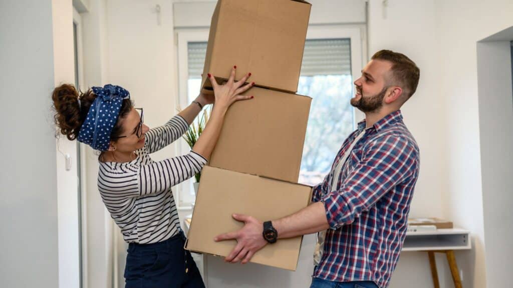 a couple moving boxes in a home